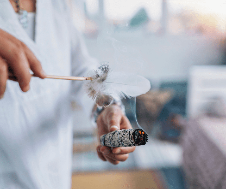 Mulher fazendo defumação com ervas sagradas