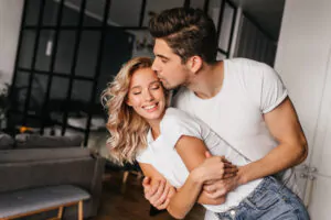 como saber se a amarração vai dar certo: homem abraçando mulher por trás enquanto beija seu rosto